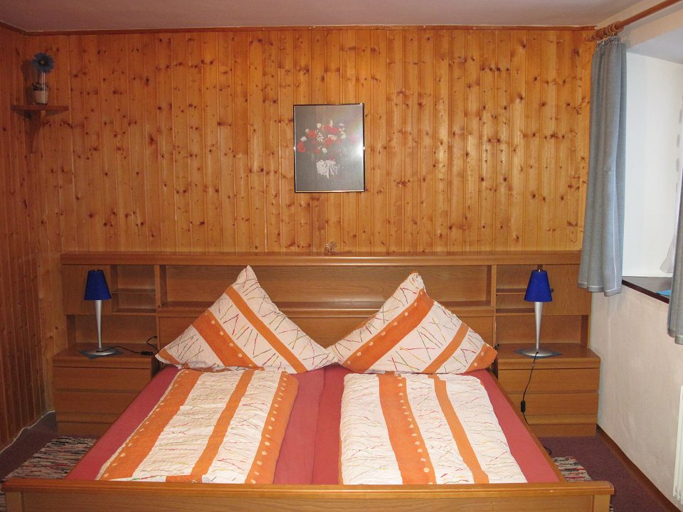 Schlafzimmer mit Doppelbett und Holzvertäfelung